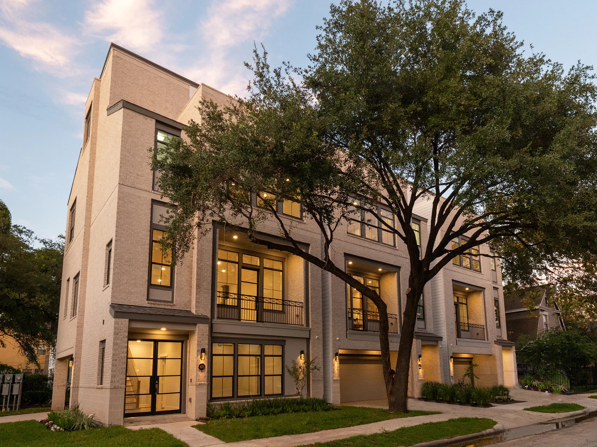 Hyde Park custom residential exterior at dusk in Houston with warm interior light and mature trees