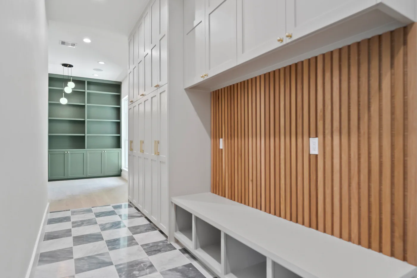 Wedgewood mudroom with wood slat wall and marble flooring